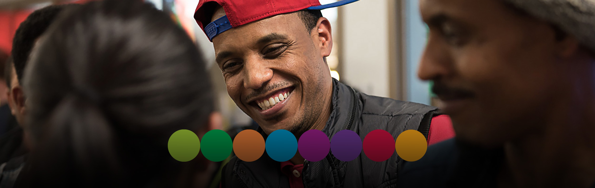  Photo of student smiling with a red backwards baseball cap on 