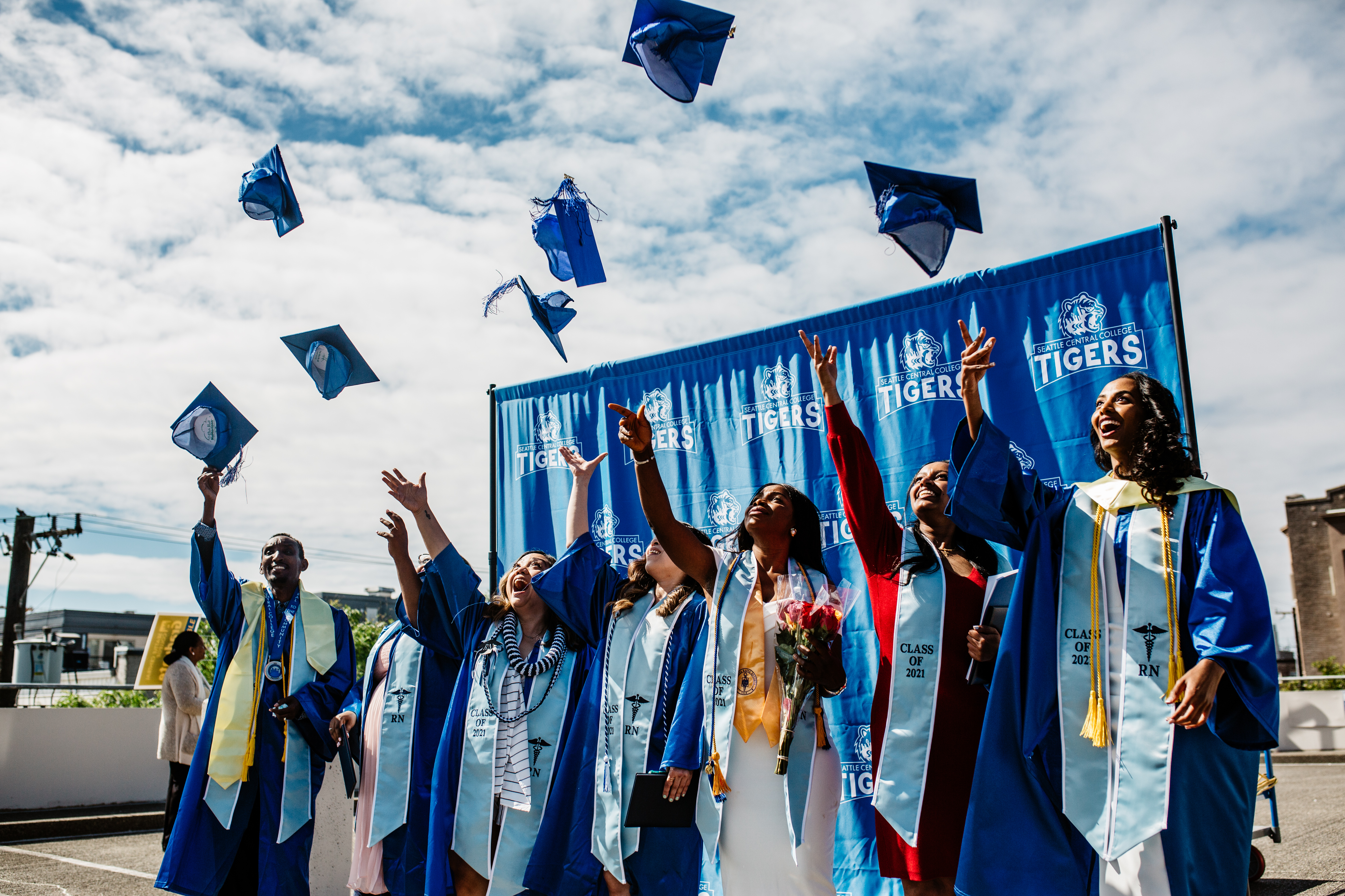 nursing students throw their caps during a commencement event